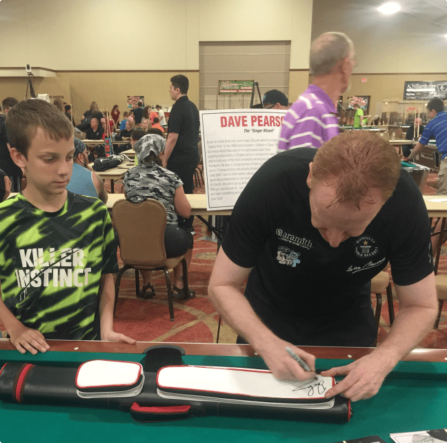 Dave signing an autograph on the pool cue case for a fan at the Iowa Tournament